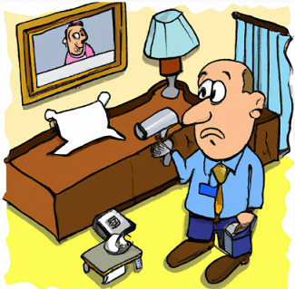 man looking for hidden camera in hotel room